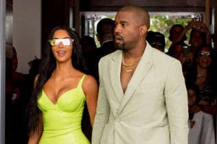 Kim Kardashian shined extra bright in neon and she and Kanye West arrive at Miamis Versace Mansion for rapper 2Chainz Wedding on Saturday